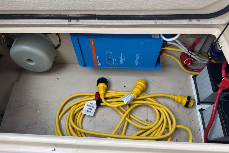 Slide: The Image of 2019 Ranger Tugs R-31 S electrical compartment with yellow power cables and blue inverter. - 39