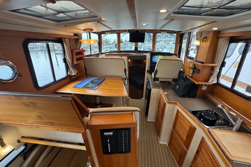 Slide: The Image of 2019 Ranger Tugs R-31 S interior with wood accents, dining area, and navigation station. - 5