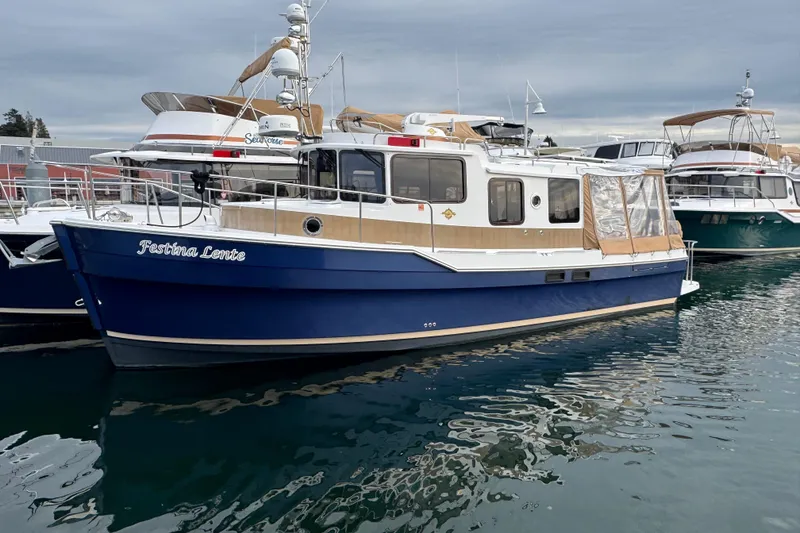 Slide: The Image of 2019 Ranger Tugs R-31 S boat docked in marina, blue hull, calm water. - 50