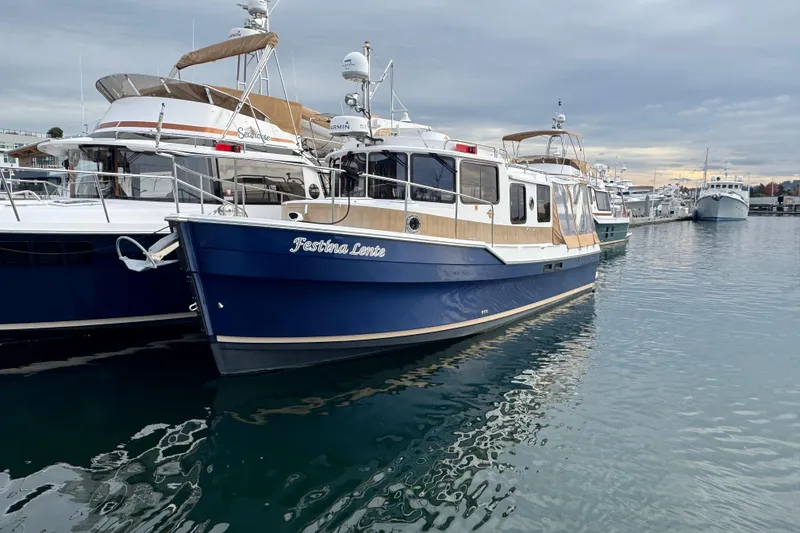 Slide: The Image of 2019 Ranger Tugs R-31 S boat docked in marina, blue hull, calm water. - 51