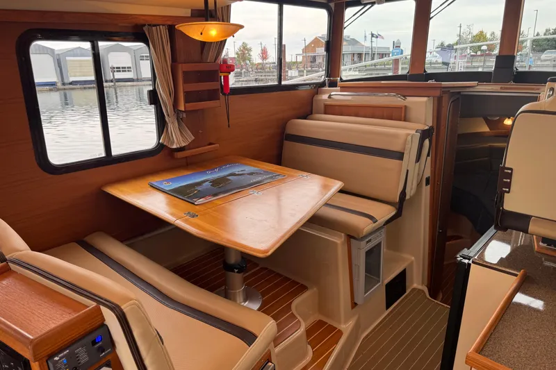 Slide: The Image of Interior of 2019 Ranger Tugs R-31 S with cozy dining area and window view. - 7