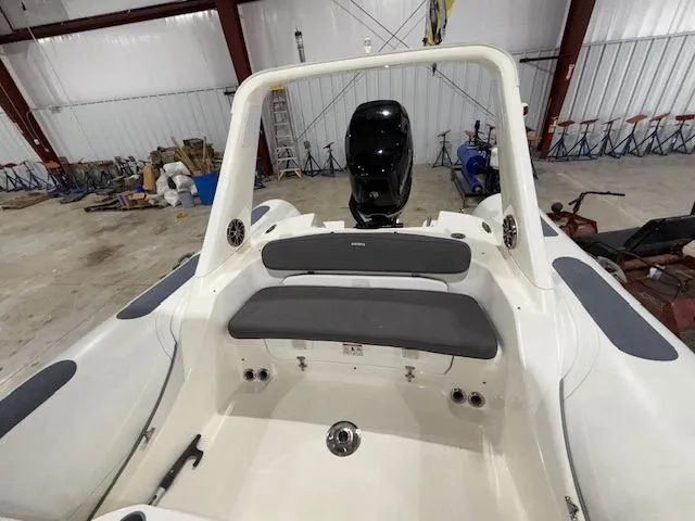 Slide: The Image of 2015 Brig Inflatables Eagle 780 boat interior with seating and motor in a warehouse. - 5