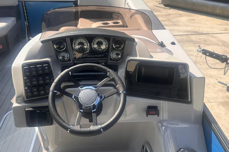 Slide: The Image of 2026 Starcraft CX 23 DL BAR boat dashboard with steering wheel and control panel. - 16