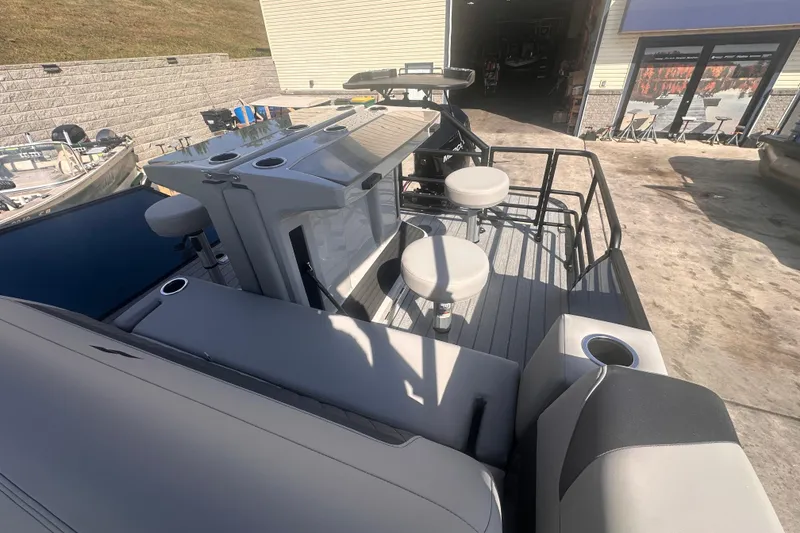 Slide: The Image of 2026 Starcraft CX 23 DL BAR boat with seating and bar area, docked outdoors. - 7