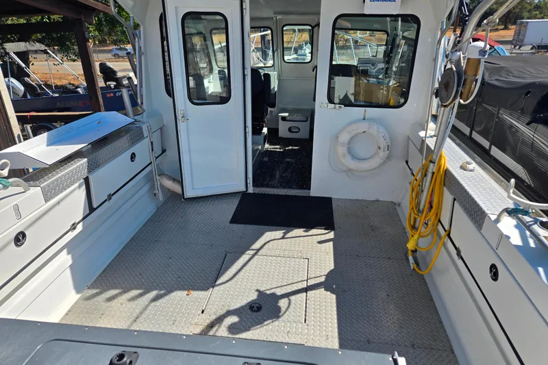 Slide: The Image of 2020 Raider 250 Sea Raider boat interior with open cabin door and deck equipment. - 10