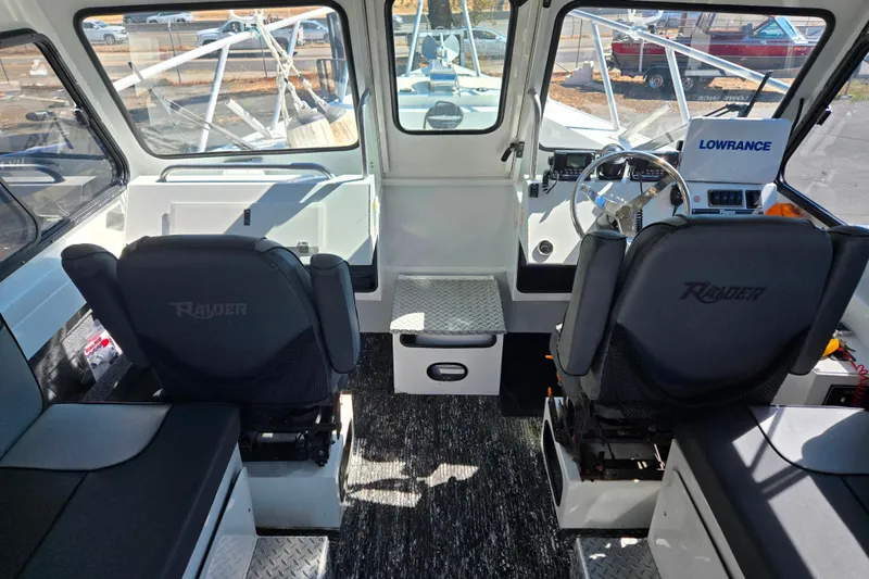 Slide: The Image of Interior of 2020 Raider 250 Sea Raider boat with steering console and seating. - 11