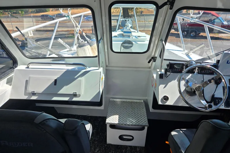 Slide: The Image of Interior view of 2020 Raider 250 Sea Raider boat cockpit with steering wheel and controls. - 14