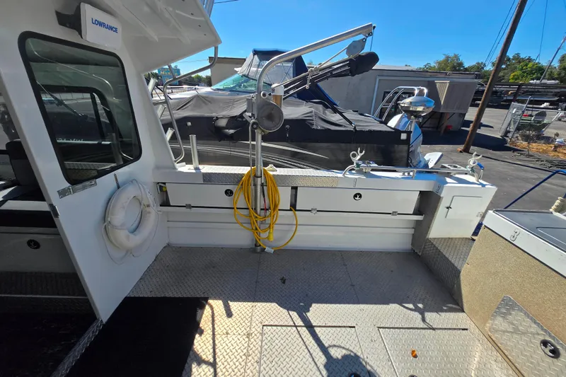 Slide: The Image of 2020 Raider 250 Sea Raider boat deck with fishing equipment and storage compartments. - 20