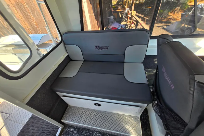 Slide: The Image of Interior seating of 2020 Raider 250 Sea Raider boat, featuring comfortable cushions. - 23