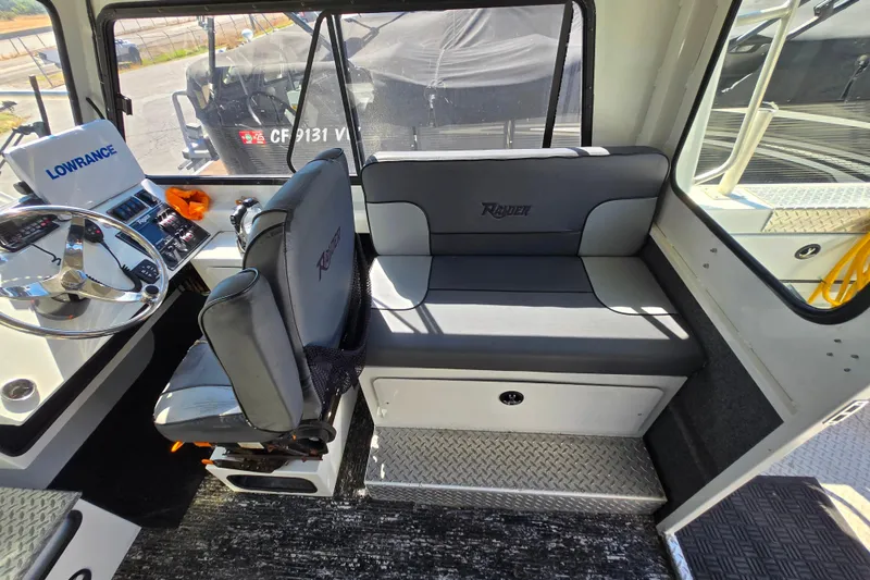 Slide: The Image of Interior of 2020 Raider 250 Sea Raider boat with steering wheel and seating. - 24