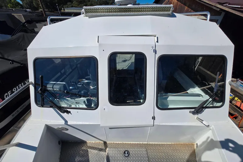 Slide: The Image of 2020 Raider 250 Sea Raider boat with windshield and wipers, docked outdoors. - 25