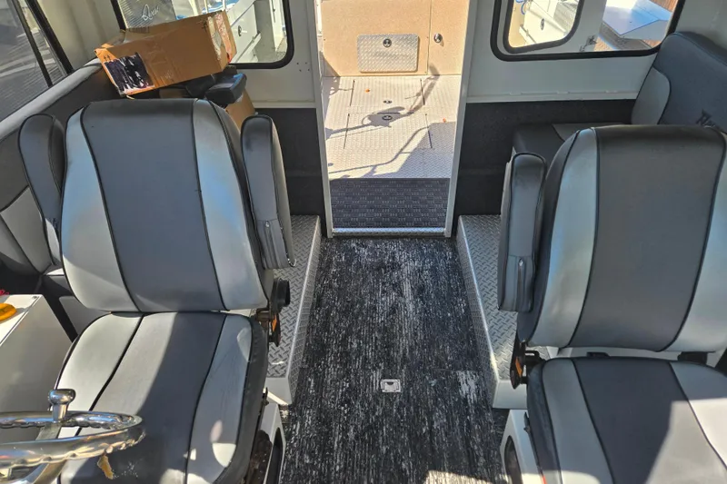 Slide: The Image of Interior of 2020 Raider 250 Sea Raider boat with gray seating and open cabin door. - 27