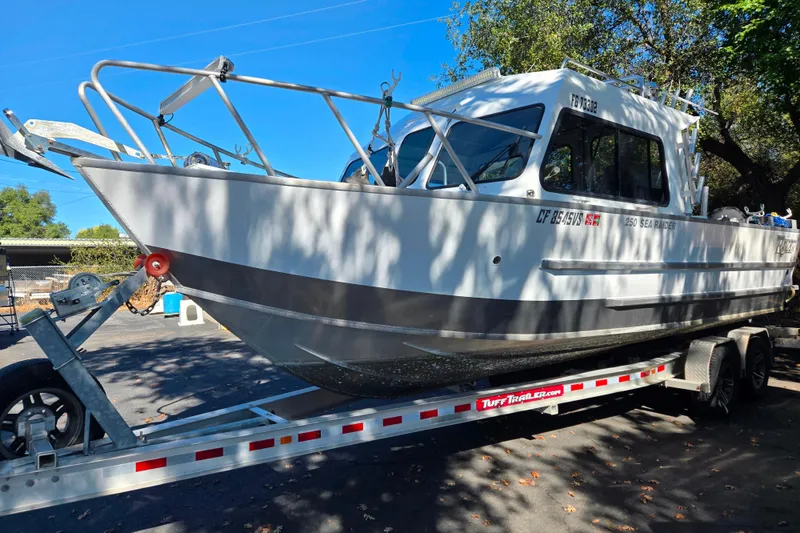 Slide: The Image of 2020 Raider 250 Sea Raider boat on trailer, parked outdoors under trees. - 3