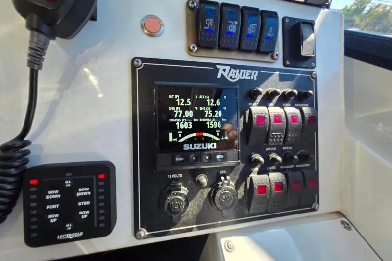 Slide: The Image of Control panel of 2020 Raider 250 Sea Raider boat with Suzuki display and switches. - 9