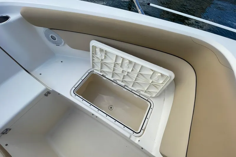Slide: The Image of 2015 Scout 245 Dorado boat storage compartment with open lid, beige interior. - 13