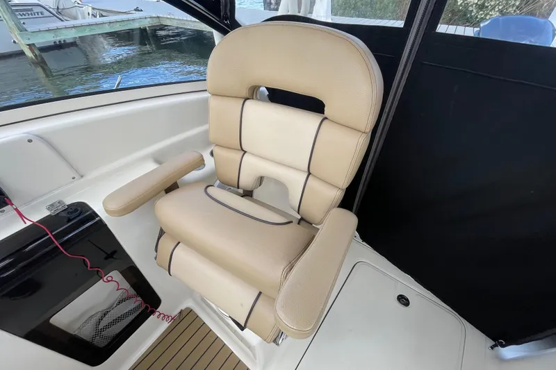 Slide: The Image of 2015 Scout 245 Dorado boat seat with beige upholstery and armrests. - 16