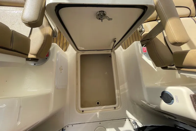 Slide: The Image of 2015 Scout 245 Dorado boat interior with open storage compartment and beige seating. - 31
