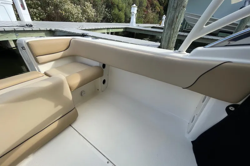 Slide: The Image of 2015 Scout 245 Dorado boat interior with beige seating near dock. - 39