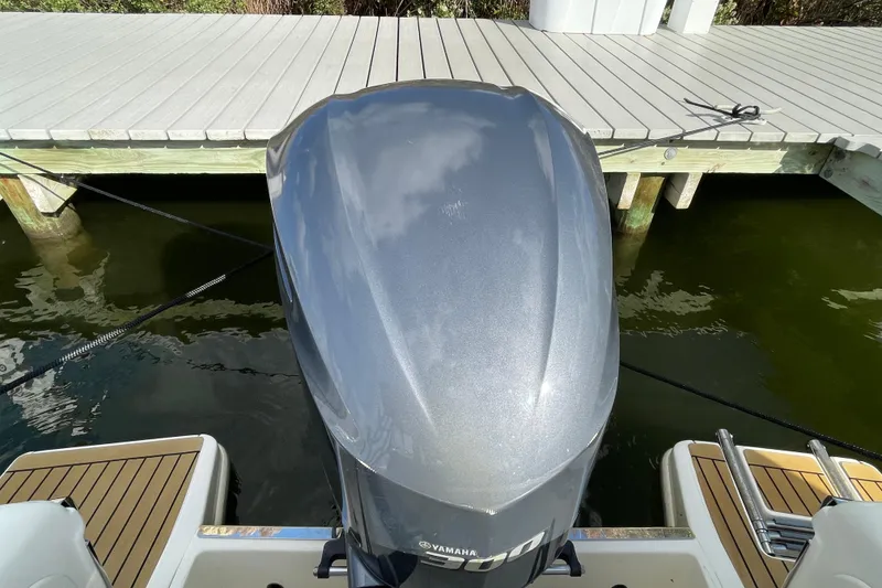 Slide: The Image of Outboard motor on 2015 Scout 245 Dorado boat docked by wooden pier. - 47
