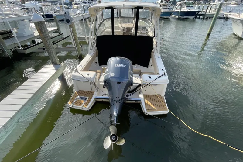 Slide: The Image of 2015 Scout 245 Dorado boat docked with outboard motor in marina. - 51