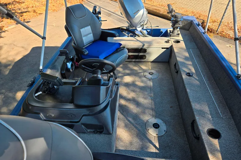 Slide: The Image of 2022 Alumacraft Escape 145 CS boat interior with steering console and seating. - 10