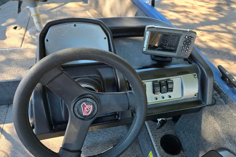 Slide: The Image of 2022 Alumacraft Escape 145 CS dashboard with steering wheel and fish finder. - 6