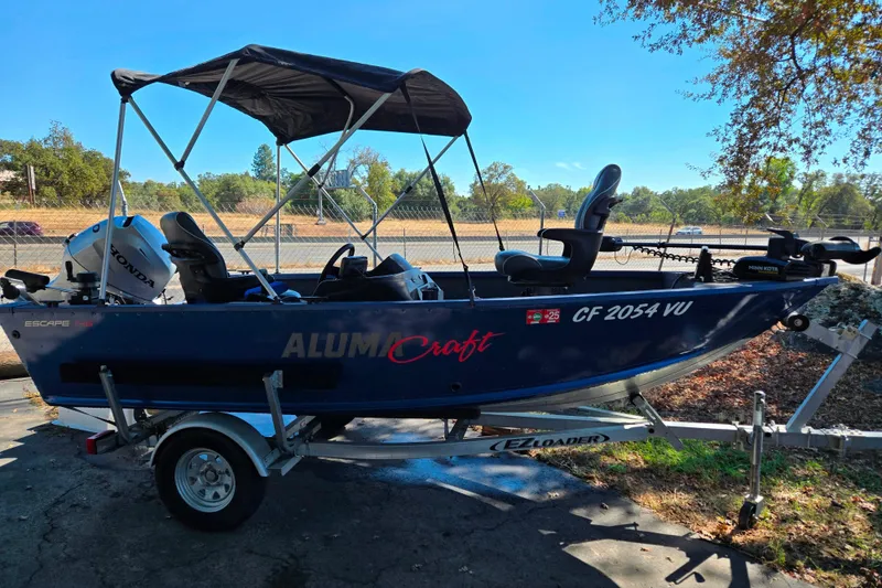 Slide: The Image of 2022 Alumacraft Escape 145 CS boat on trailer with canopy and Honda motor. - 9