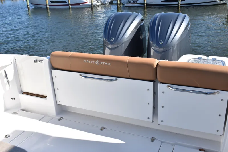 Slide: The Image of 2025 NauticStar 332 Offshore boat with twin engines, docked at marina. - 14