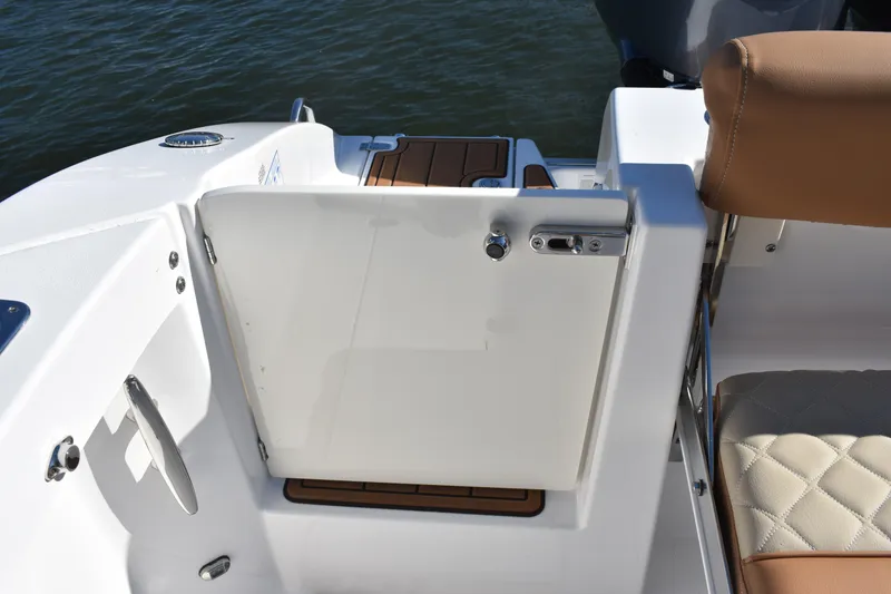 Slide: The Image of 2025 NauticStar 332 Offshore boat interior with white door and tan seating. - 15