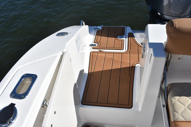 Slide: The Image of 2025 NauticStar 332 Offshore boat deck with teak flooring and cushioned seating. - 16