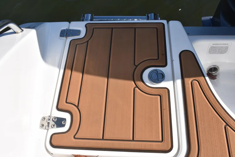 Slide: The Image of 2025 NauticStar 332 Offshore boat deck with wood finish and metal fittings. - 18