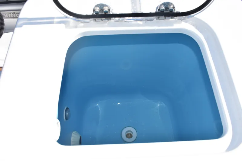 Slide: The Image of Livewell compartment on 2025 NauticStar 332 Offshore boat, featuring a blue interior. - 24