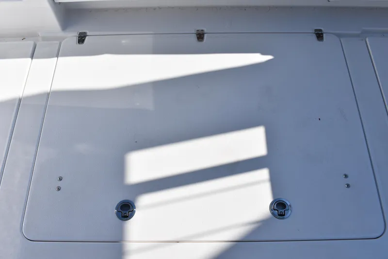 Slide: The Image of 2025 NauticStar 332 Offshore deck with shadows and latches. - 25