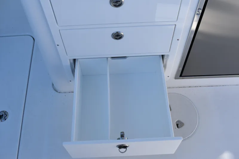 Slide: The Image of Open storage drawer on 2025 NauticStar 332 Offshore boat, showcasing organized compartments. - 36