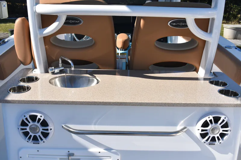 Slide: The Image of 2025 NauticStar 332 Offshore boat interior with sink, cup holders, and speakers. - 41