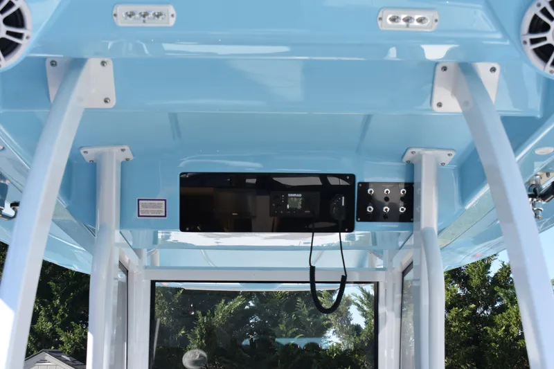 Slide: The Image of 2025 NauticStar 332 Offshore boat interior with blue ceiling and electronic controls. - 43