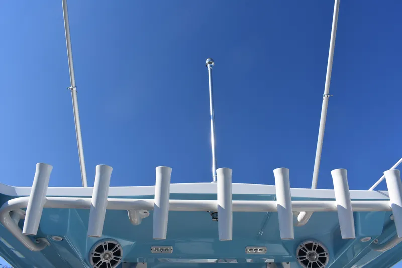 Slide: The Image of 2025 NauticStar 332 Offshore boat, blue sky, fishing rod holders, and speakers. - 45