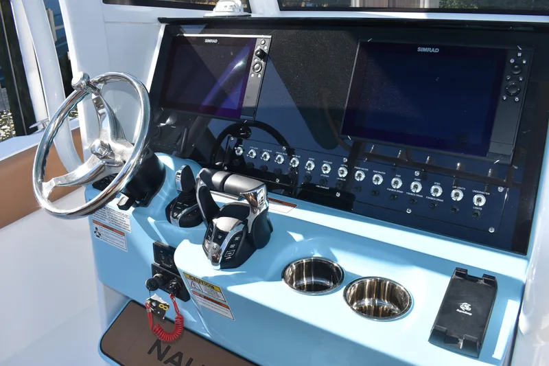 Slide: The Image of 2025 NauticStar 332 Offshore boat dashboard with steering wheel and control panel. - 51