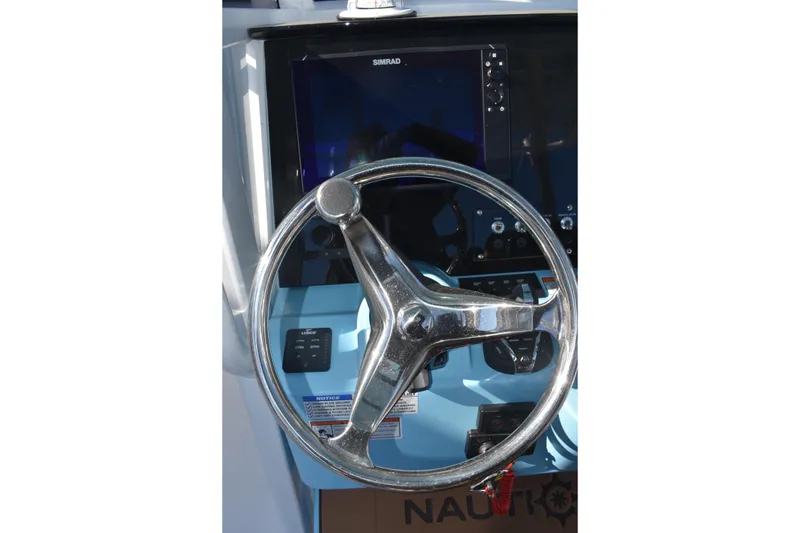 Slide: The Image of Steering wheel of 2025 NauticStar 332 Offshore boat with navigation controls. - 52