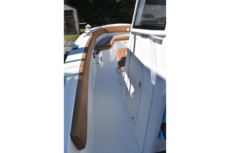 Slide: The Image of 2025 NauticStar 332 Offshore boat interior with brown seating and white deck. - 56