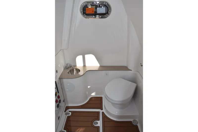 Slide: The Image of 2025 NauticStar 332 Offshore boat bathroom with sink, toilet, and wooden floor accents. - 58
