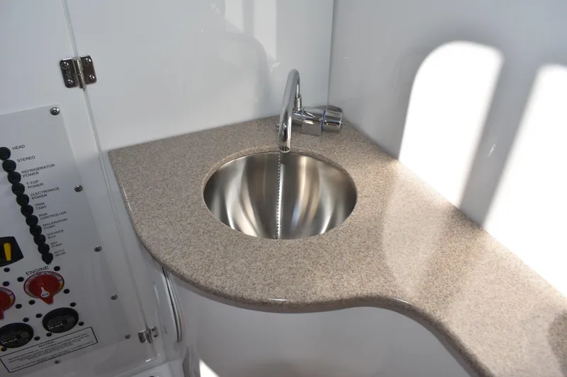 Slide: The Image of 2025 NauticStar 332 Offshore boat interior with sleek sink and control panel. - 61