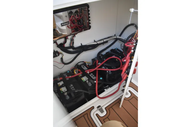 Slide: The Image of 2025 NauticStar 332 Offshore boat battery compartment with wiring and electrical components. - 62