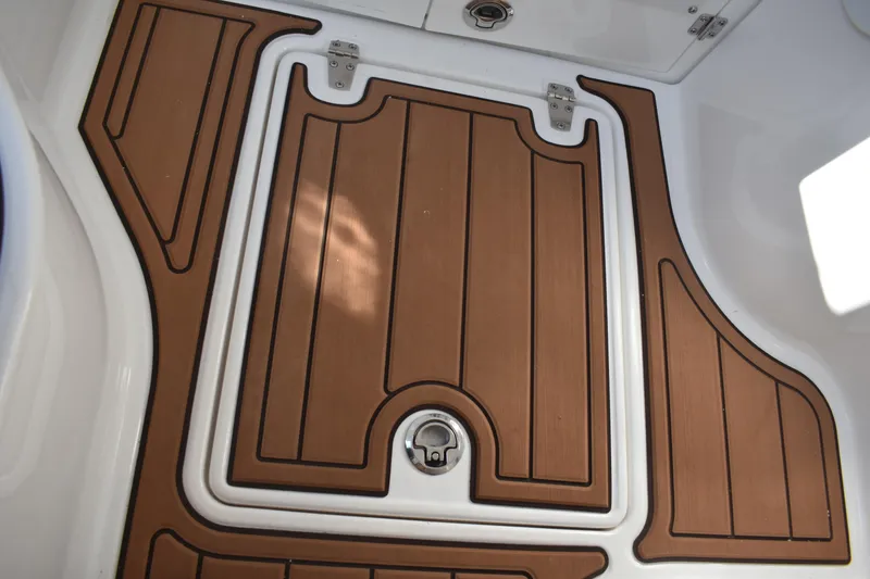 Slide: The Image of 2025 NauticStar 332 Offshore boat deck with wood finish and secure hatch. - 64
