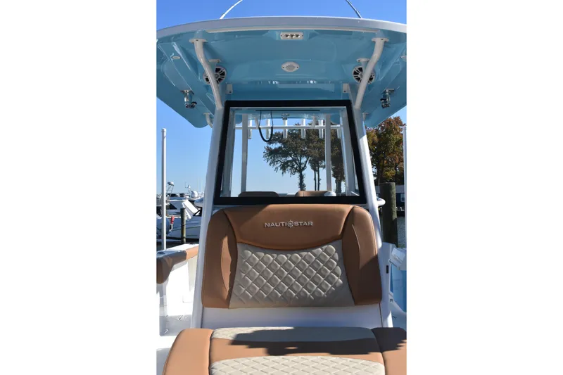 Slide: The Image of 2025 NauticStar 332 Offshore boat interior with cushioned seating and blue canopy. - 70