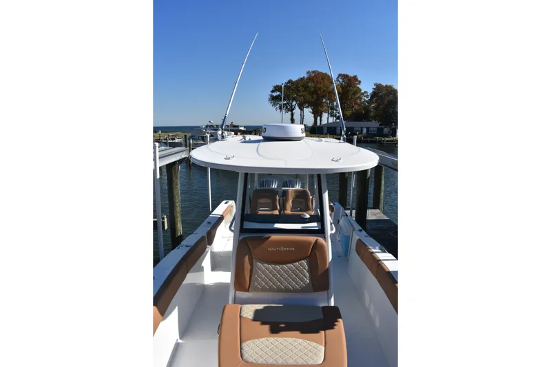 Slide: The Image of 2025 NauticStar 332 Offshore boat docked, showcasing sleek design and comfortable seating. - 84