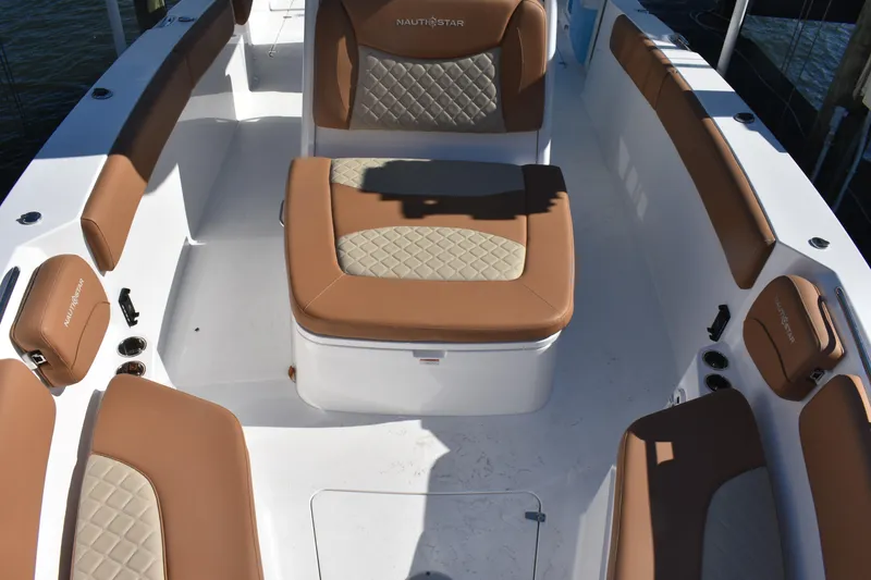 Slide: The Image of 2025 NauticStar 332 Offshore boat interior with tan cushioned seating and white deck. - 86