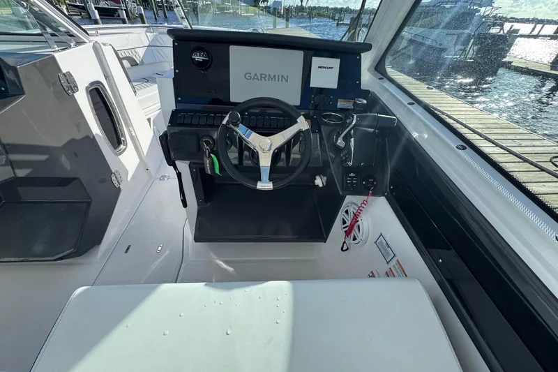 Slide: The Image of 2025 Blackfin 272 DC boat on water near marina, featuring Mercury engine. - 10