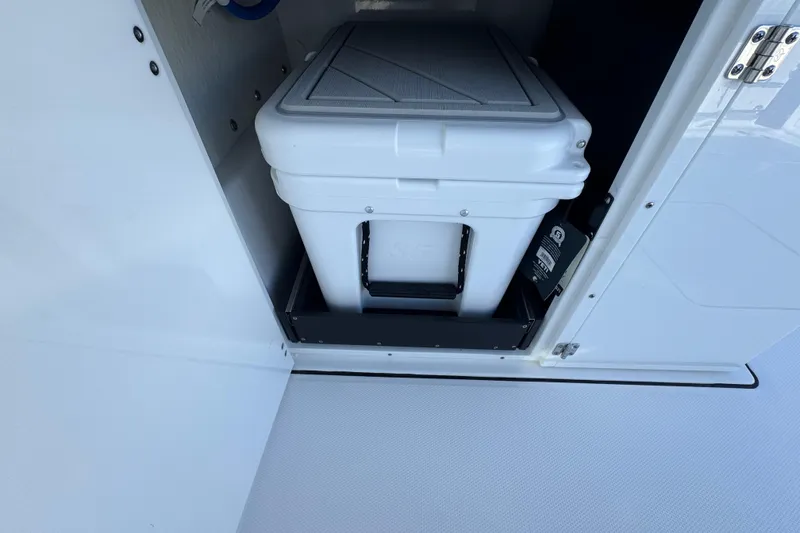 Slide: The Image of 2025 Blackfin 272 DC boat interior with sleek white cabinetry and seating by the water. - 15