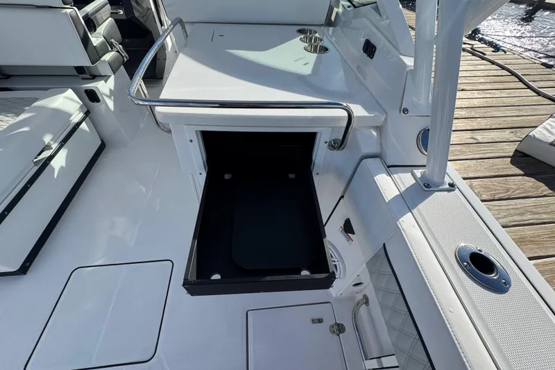Slide: The Image of 2025 Blackfin 272 DC boat interior with storage compartments and seating, overlooking water. - 17
